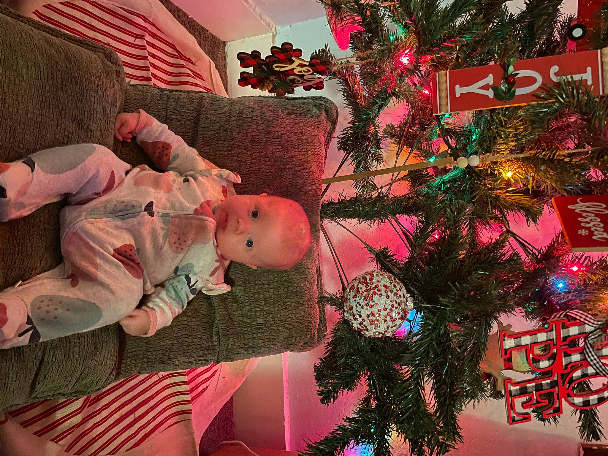 Addilyn joined the competition — help win amazing prizes! baby, baby_toddler_clothing, christmas, christmas_decoration, christmas_eve, christmas_ornament, christmas_tree, conifer, event, evergreen, flag, happy, holiday, holiday_ornament, ornament, person, pink, plant, red, toddler