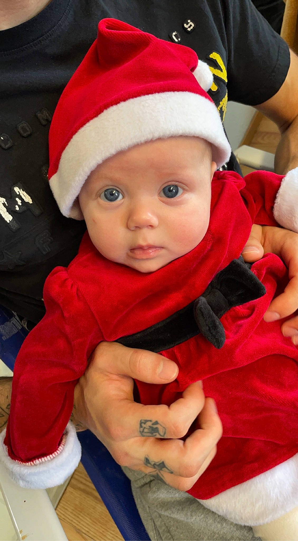 Addilyn is registered to the contest to win money with this photo: baby, baby_toddler_clothing, cap, child, christmas, event, eye, facial_expression, fictional_character, finger, gesture, hand, happy, headwear, holiday, outerwear, person, red, santa_claus, skin
