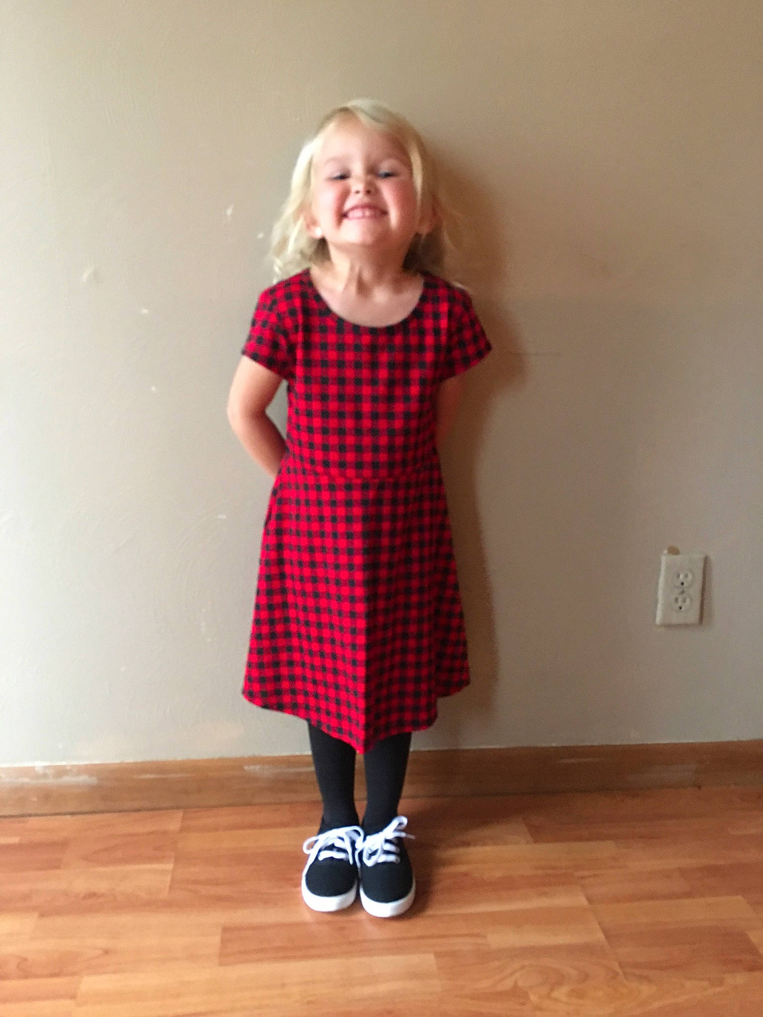 Kinslee is registered to the contest to win money with this photo: baby_toddler_clothing, blond, child, child_model, day_dress, dress, floor, flooring, hardwood, human_leg, joy, laminate_flooring, mouth, pattern, person, shoulder, sleeve, standing, toddler, wood