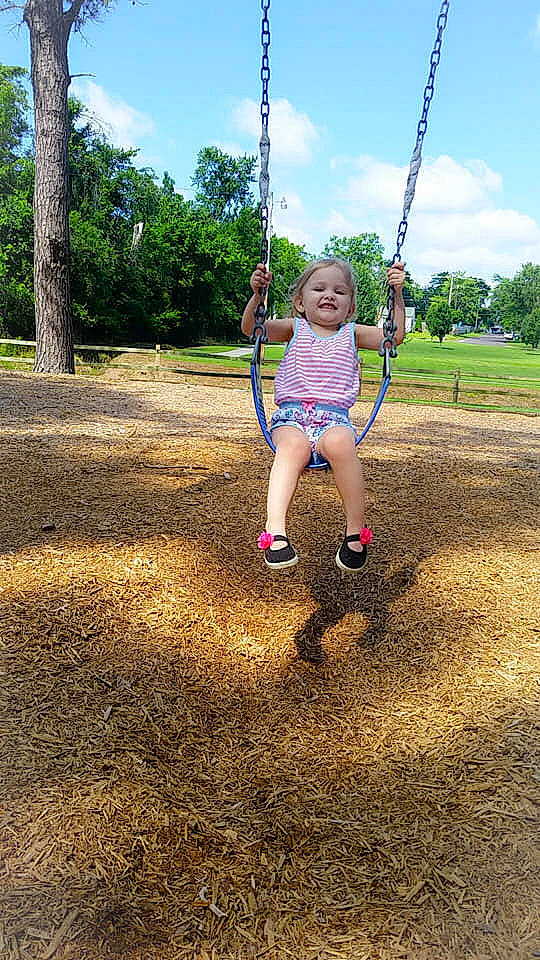 Kinslee is registered to the contest to win money with this photo: child, city, fun, grass, human_settlement, leisure, outdoor_play_equipment, park, person, plant, play, playground, public_space, recreation, rope, soil, summer, swing, toddler, tree