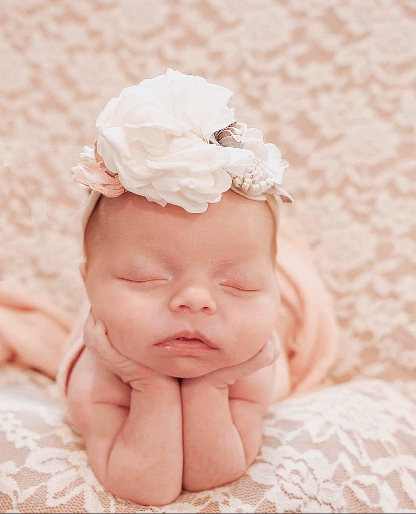 Ellie joined the competition — help win amazing prizes! arm, baby, baby_sleeping, baby_toddler_clothing, eyebrow, face, flower, gesture, hand, happy, head, headband, headgear, headpiece, jewellery, person, petal, picture_frame, pink, thumb