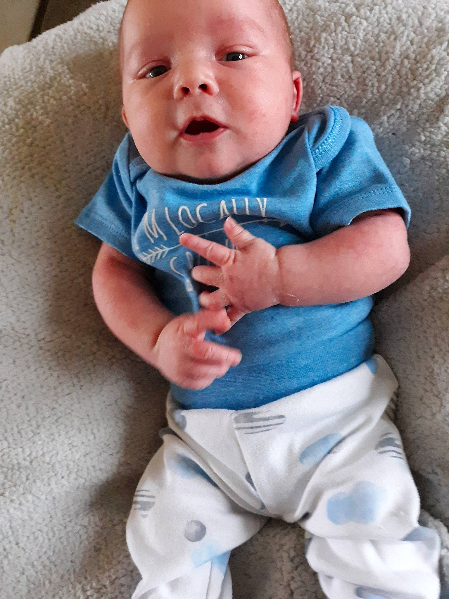 Oakley is registered to the contest to win money with this photo: baby, baby_products, baby_toddler_clothing, blue, cheek, child, facial_expression, nose, person, product, sitting, skin, sleeve, smile, t_shirt, toddler, turquoise