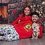 couple, dog, christmas_tree, fireplace, holiday, pajamas, smiling, gift_box, floor, decorations, festive, indoor, happy, portrait, warmth, celebration, seasonal, togetherness, cute, pet