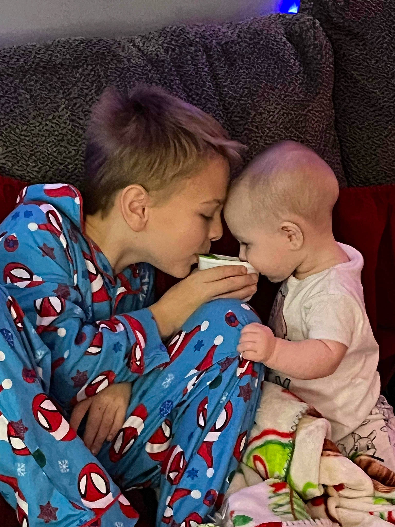 Zac is registered to the contest to win money with this photo: baby, baby_toddler_clothing, cheek, child, comfort, couch, event, fun, happy, head, hug, lap, linens, love, pattern, person, sitting, skin, sleeve, t_shirt