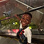 child, boy, smile, escalator, urban, night, railing, white_shirt, sunglasses, crocs, happy, portrait, casual_clothing, glass, reflection, background, person, standing, looking_up, handrail