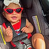 Taliyah is registered to the contest to win money with this photo: baby, child, infant, car_seat, sunglasses, bow, red_clothing, smiling, happy, portrait, seated, seatbelt, harness, vehicle, interior, close_up, fashion, accessories, safe, road_trip