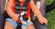 Taliyah joined the competition — help win amazing prizes! baby, baby_feet, bow, car_seat, child, denim_shorts, garden, grass, happy, harness, headband, infant, outdoor, portrait, red_shirt, sitting, smiling, sunlight, teething_toy, toy