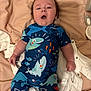 baby, infant, child, lying_down, blue_clothing, shark_pattern, blanket, onesie, hairbrush, soft_fabric, cute, expression, chubby, indoors, sleepwear, bedroom, closeup, person, newborn, portrait
