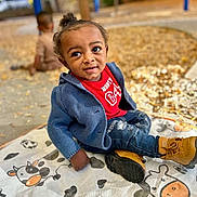 Kamari joined the competition — help win amazing prizes! toddler, child, outdoor, playground, autumn, fall, leaves, blue_sweater, boots, jeans, mat, cow_pattern, curious, person, sitting, blurred_background, play, park, casual_clothing, daylight