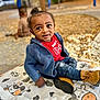 toddler, child, outdoor, playground, autumn, fall, leaves, blue_sweater, boots, jeans, mat, cow_pattern, curious, person, sitting, blurred_background, play, park, casual_clothing, daylight