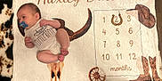 Huxley is registered to the contest to win money with this photo: baby, blanket, boots, child, clothing, cowboy_hat, cowhide, face, horseshoe, indoors, infant, lying_down, milestone_blanket, months, onesie, pacifier, skin, western_theme, wheel, wooden_floor