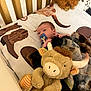 baby, bed, bedding, blanket, boots_print, child, comfort, crib, cuddly, fur_texture, horns_print, infant, nursery, pacifier, plush_toy, resting, sleeping, soft_toys, stuffed_animal, western_theme