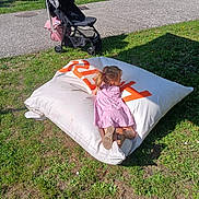 Ludmila participe au concours pour gagner de l'argent avec cette photo : child, girl, pink_dress, bean_bag, grass, outdoor, stroller, sunlight, shoes, pavement, park, play, relaxation, casual, daytime, greenery, summer, shadow, side_view, leisure