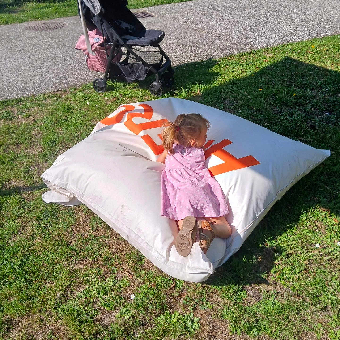 Ludmila participe au concours pour gagner de l'argent avec cette photo : bean_bag, casual, child, daytime, girl, grass, greenery, leisure, outdoor, park, pavement, pink_dress, play, relaxation, shadow, shoes, side_view, stroller, summer, sunlight