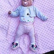 Arya participe au concours pour gagner de l'argent avec cette photo : baby, infant, pink_blanket, headband, pacifier, outdoor, grass, cute, child, clothing, footwear, minnie_mouse, slippers, pastel_colors, texture, laying_down, nature, soft, toddler, wearing