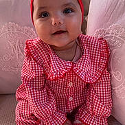 India a rejoint le concours — aidez-le/la à gagner de superbes lots ! baby, child, infant, red_bow, headband, gingham, plaid, red_and_white, sitting, couch, pillows, soft_fabric, smiling, cute, indoors, cozy, dress, white_socks, hands, portrait