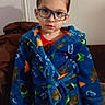 blue_robe, boy, carpet, child, couch, cozy, dinosaur_pattern, expressionless, face, glasses, hands, indoor, kid, living_room, looking_at_camera, pajamas, portrait, short_hair, standing, wall