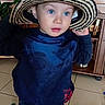 blue_eyes, bottle_caps, child, cute, drawer, hands_up, hat, home_interior, indoor, jeans, looking_up, plant, playful, portrait, straw_hat, sweater, tiled_floor, toddler, toy, wooden_cabinet