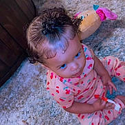 Karaji joined the competition — help win amazing prizes! baby, child, infant, sitting, portrait, face, curly_hair, smiling, looking_up, pink_outfit, patterned_clothing, cherry_pattern, rug, carpet, plush_toy, indoor, home, floor, cozy, toy