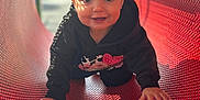 Ella is registered to the contest to win money with this photo: child, toddler, crawling, playground, red_tunnel, sunlight, shadow_pattern, happy, hoodie, outdoor, daylight, smile, face, curious, play, metal, perforated_surface, cute, young_child, fun