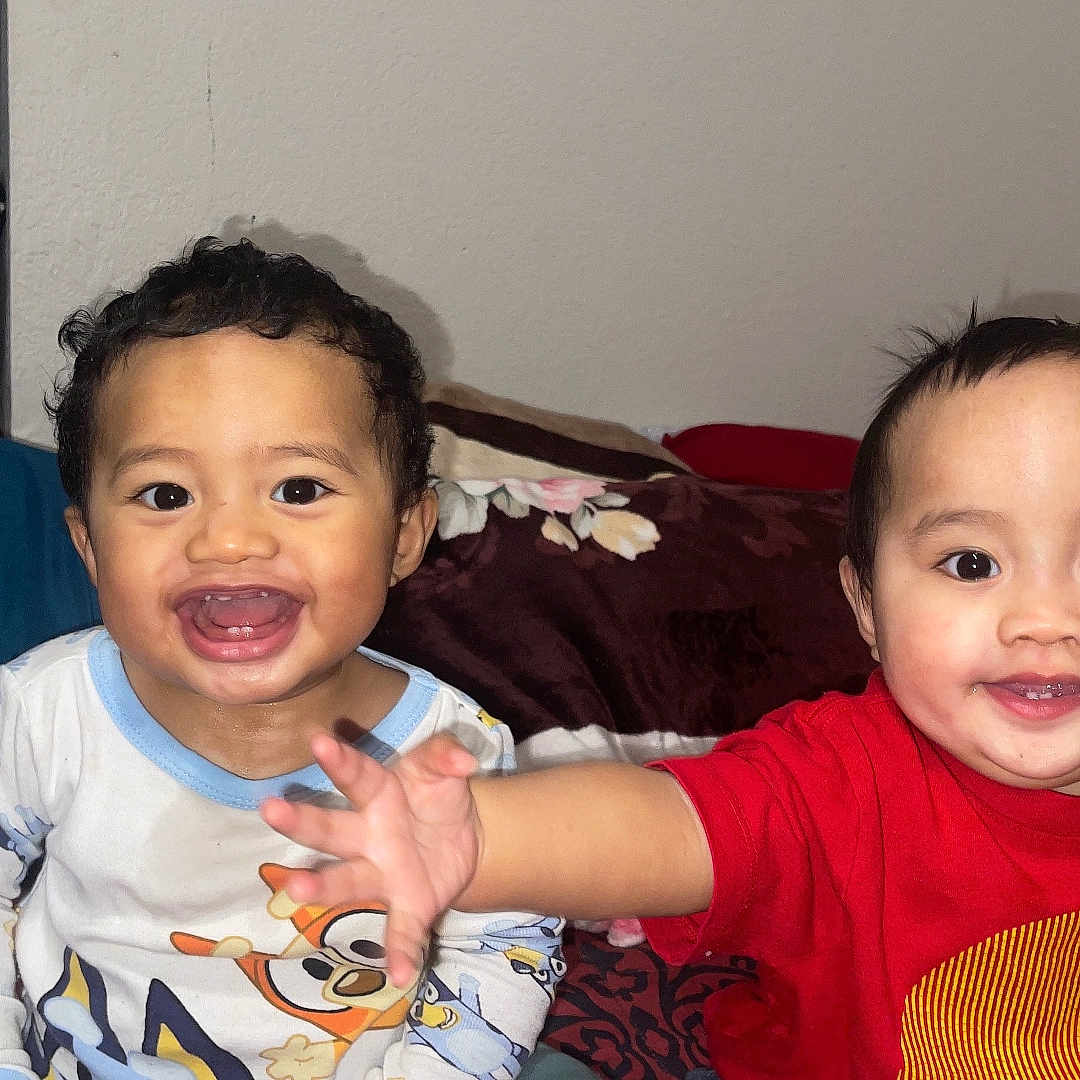 Isaiah-Isaac is registered to the contest to win money with this photo: bed, blanket, child, clothing, cute, expression, face, furniture, happy, home, indoor, pajamas, person, playful, portrait, room, smiling, toddler, two_children, young_child