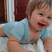 Keith joined the competition — help win amazing prizes! baby, infant, smiling, blue_onesie, lying_down, happy, indoor, blanket, child, cute, face, hands, skin, hair, door, wooden_door, room, portrait, close_up, expression