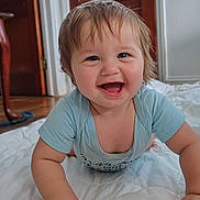 Keith joined the competition — help win amazing prizes! baby, smiling, crawling, indoor, blue_shirt, quilt, happy, child, person, furniture, wooden_door, floor, hand, face, head, skin, hair, eyes, mouth, tongue