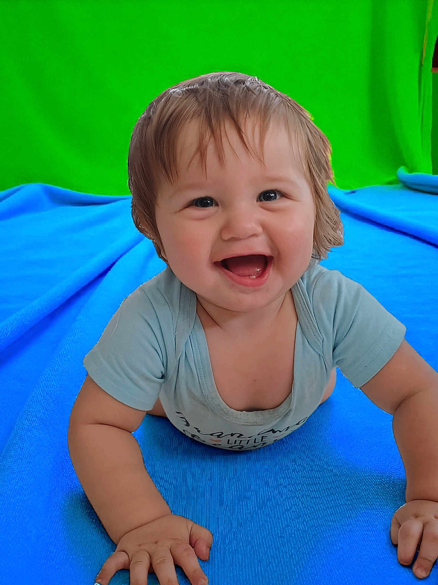 Keith is registered to the contest to win money with this photo: baby, smiling, crawling, blue_blanket, green_background, happy, child, cute, infant, short_hair, indoor, portrait, toddler, clothing, skin, hand, face, eyes, mouth, expression