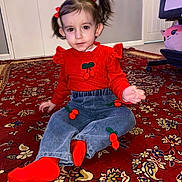 Elif joined the competition — help win amazing prizes! blue_pants, carpet, cherry, child, clothing, cute, floor, hair_bows, home, indoor, patterned_rug, person, pigtails, portrait, red_socks, red_sweater, sitting, smile, toddler, young_child