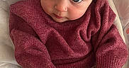 Maggie joined the competition — help win amazing prizes! baby, infant, child, sweater, floral_pants, sitting, cushion, seat, blue_eyes, cute, cozy, indoors, warning_label, hands, feet, socks, soft_texture, portrait, young_child, curious
