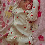 Meadow joined the competition — help win amazing prizes! baby, infant, pink_headband, pacifier, onesie, cherry_pattern, blanket, floral, cute, newborn, sleepwear, lying_down, indoors, soft_texture, adorable, child, portrait, headband, bedtime, comfort