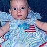 Meadow is registered to the contest to win money with this photo: american_flag, baby, blue_eyes, child, closeup, clothing, cute, expression, fabric, face, indoors, infant, person, photography, portrait, sitting, soft_lighting, striped_dress, texture, young