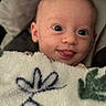 Meadow is registered to the contest to win money with this photo: baby, face, tongue, blanket, cozy, closeup, cute, infant, expression, child, portrait, soft, warm, indoors, young, smiling, person, head, skin, sleepy