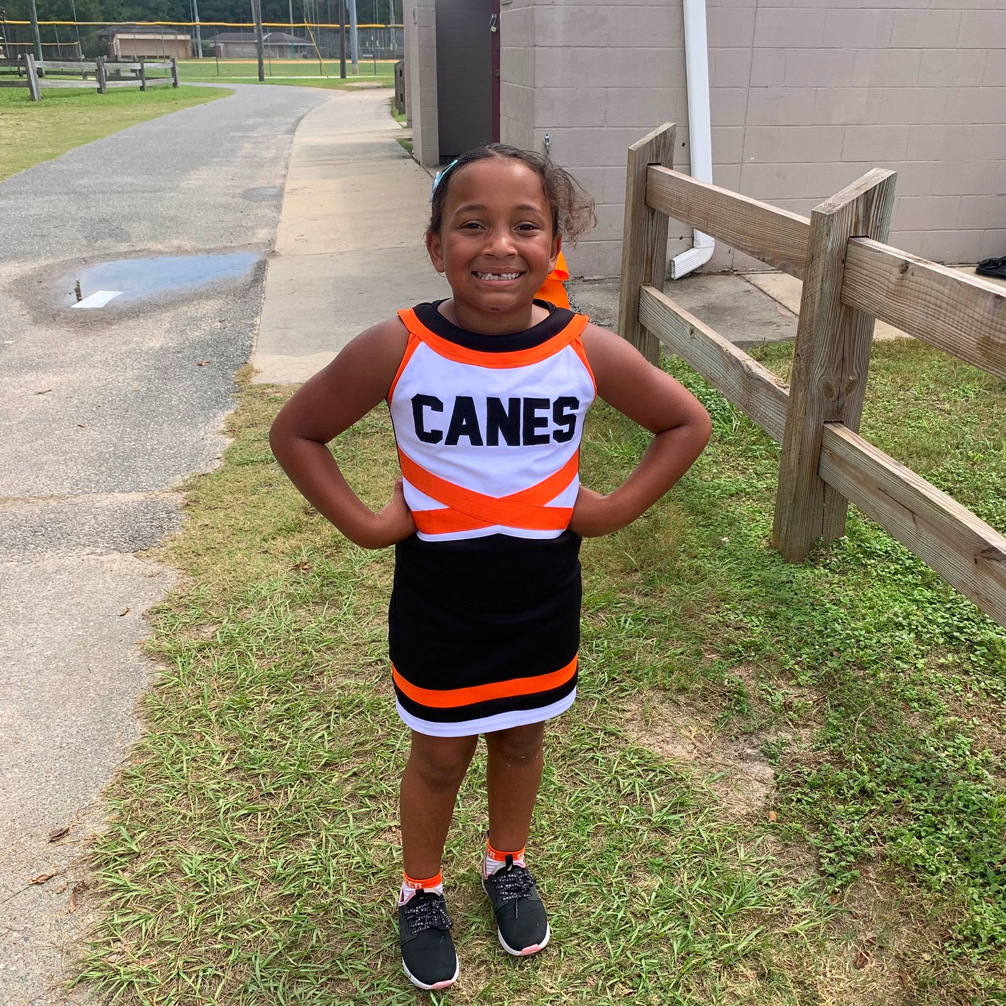 Gersey is registered to the contest to win money with this photo: asphalt, concrete, fence, fun, grass, happy, human_leg, jersey, joy, pattern, person, plant, recreation, road_surface, shorts, sleeve, smile, sportswear, t_shirt, thigh