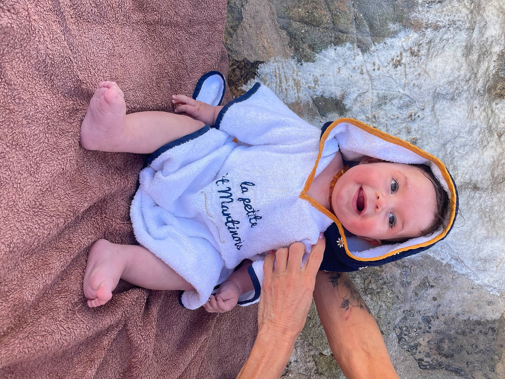 Sia participe au concours pour gagner de l'argent avec cette photo : baby_toddler_clothing, child, foot, fun, grass, happy, hat, headwear, human_leg, landscape, leisure, mammal, person, sitting, skin, sleeve, smile, t_shirt, thigh, toddler