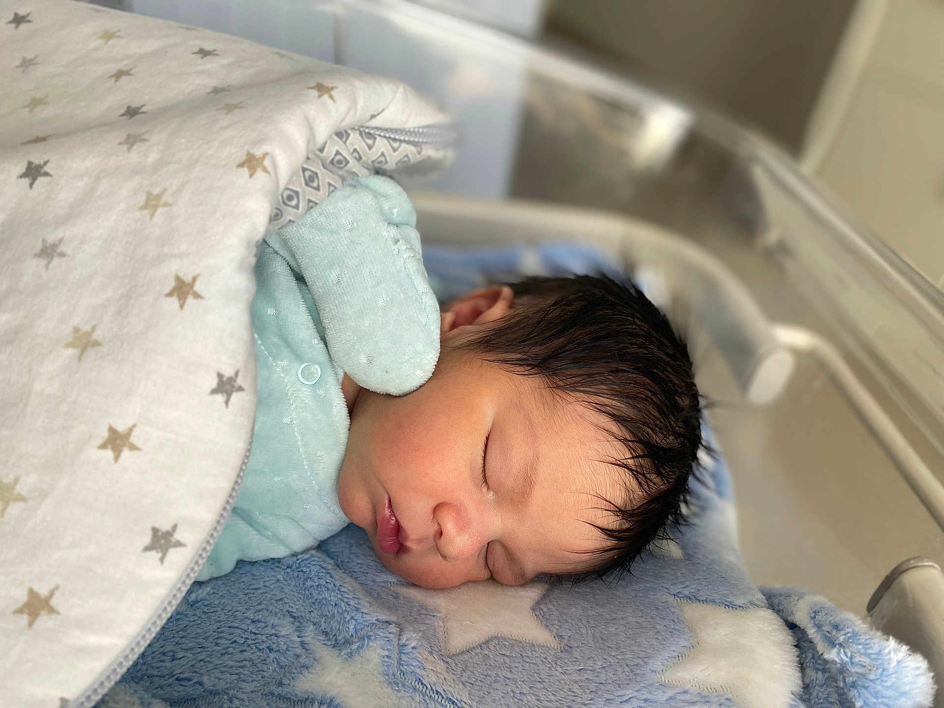 Ilyes participe au concours pour gagner de l'argent avec cette photo : newborn, baby, sleeping, blanket, star_pattern, mittens, blue, soft_texture, infant, closeup, face, peaceful, bed, cushion, cozy, indoors, portrait, resting, child, cute