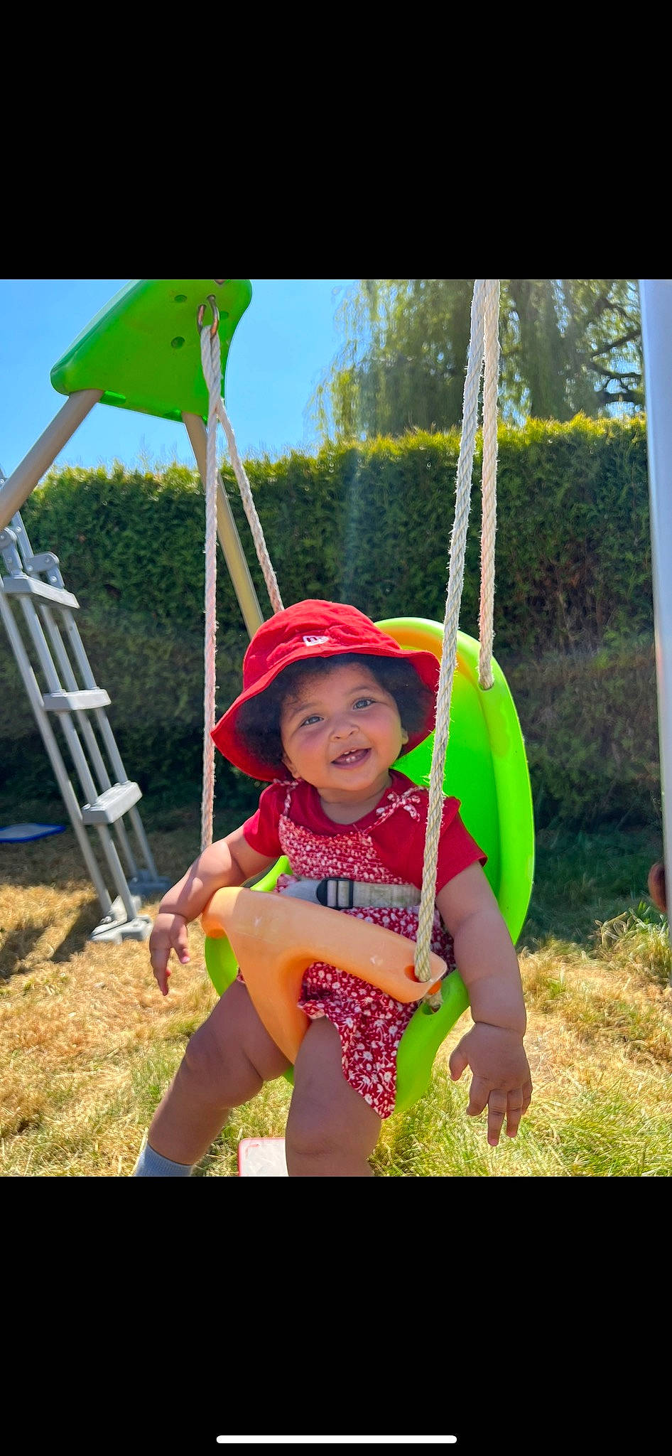 Shaïma participe au concours pour gagner de l'argent avec cette photo : baby_toddler_clothing, fun, grass, happy, headwear, leisure, magenta, outdoor_play_equipment, people_in_nature, person, photograph, plant, recreation, shade, shorts, sky, smile, snapshot, summer, swing
