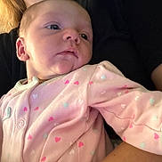 Evelynn joined the competition — help win amazing prizes! baby, infant, pink_onesie, hearts, face, person, child, newborn, skin, cute, portrait, holding, caregiver, closeup, expression, soft_lighting, indoor, clothing, sleepwear, young