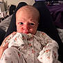 Evelynn joined the competition — help win amazing prizes! baby, infant, floral_onesie, person, indoor, legs, hand, face, eyes, skin, clothing, bedroom, blanket, television, furniture, comfort, cute, newborn, expression, portrait