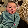 Tommy joined the competition — help win amazing prizes! baby, child, smiling, sweatshirt, sitting, indoor, couch, living_room, person, clothing, face, happy, technology, device, background, home, furniture, pattern, hair, skin