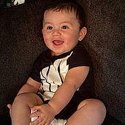 Tommy joined the competition — help win amazing prizes! baby, child, smiling, sitting, happy, couch, clothing, white_sneakers, black_shirt, person, indoor, portrait, skin, face, short_hair, cute, infant, small_hands, legs, footwear