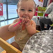 Nolan joined the competition — help win amazing prizes! baby, child, high_chair, straw, table, cafe, indoor, person, dirt, smile, clothing, wood, metal, face, hand, seat, window, background, people, casual