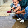 Nolan joined the competition — help win amazing prizes! adult, casual_clothing, child, concrete, fire_hose, fun, happy, holding, hose, joy, outdoor, pavement, person, play, shoes, smile, splash, support, water, water_spray