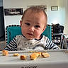 Nolan joined the competition — help win amazing prizes! toddler, baby, high_chair, food, crumbs, onesie, space_theme, face, expression, indoor, furniture, tray, person, child, seat, clothing, home, curious, messy, feeding