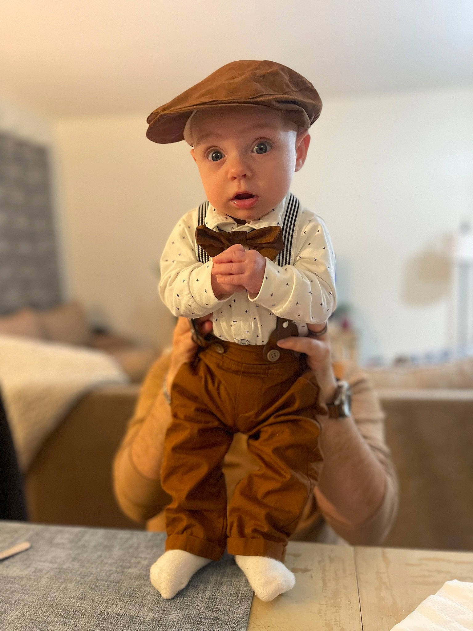 Marcus is registered to the contest to win money with this photo: abdomen, baby, child, face, fashion_accessory, figurine, flooring, fun, happy, hat, headwear, human_body, human_leg, knee, person, sitting, sleeve, sun_hat, surprise, toddler