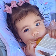 Melany joined the competition — help win amazing prizes! baby, child, girl, blue_eyes, pink_bows, teething_toy, blanket, close_up, cute, infant, face, hand, soft_lighting, portrait, adorable, young_child, skin, curly_hair, earrings, lying_down