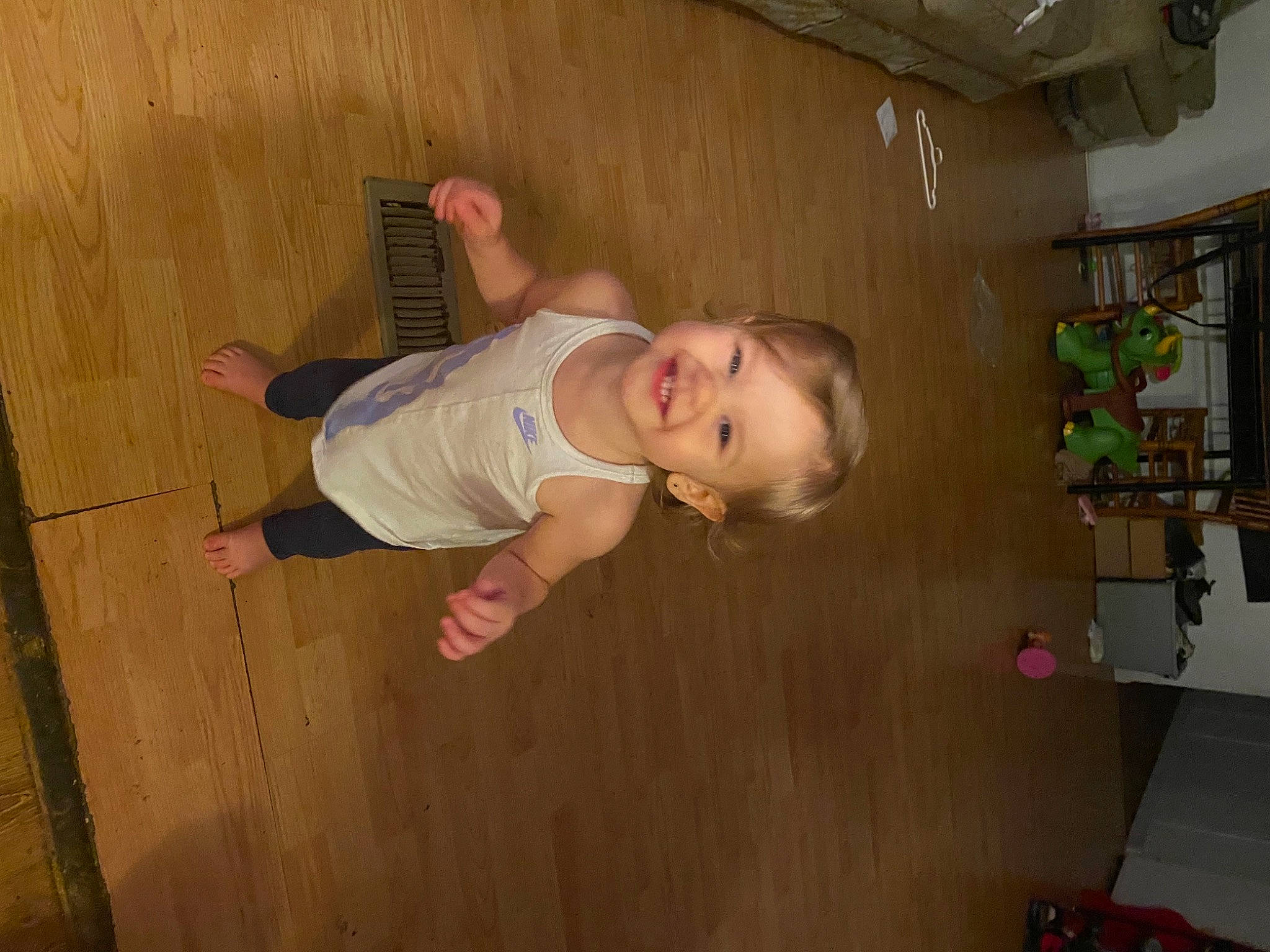 Lorelai is registered to the contest to win money with this photo: baby, baby_toddler_clothing, ceiling, child, floor, flooring, fun, happy, hardwood, joy, person, room, smile, standing, toddler, varnish, wood, wood_flooring, wood_stain