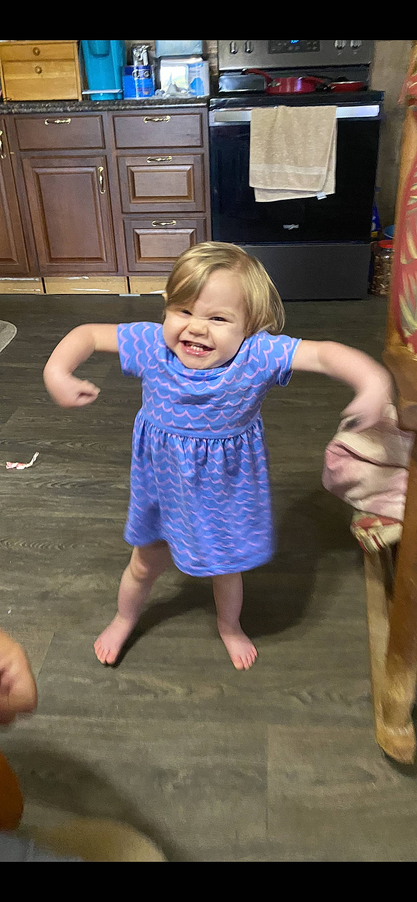 Lorelai is registered to the contest to win money with this photo: baby_toddler_clothing, cabinetry, drawer, finger, floor, flooring, fun, gesture, hand, happy, home_appliance, joint, kitchen_appliance, leg, person, shoulder, smile, standing, thumb, toddler