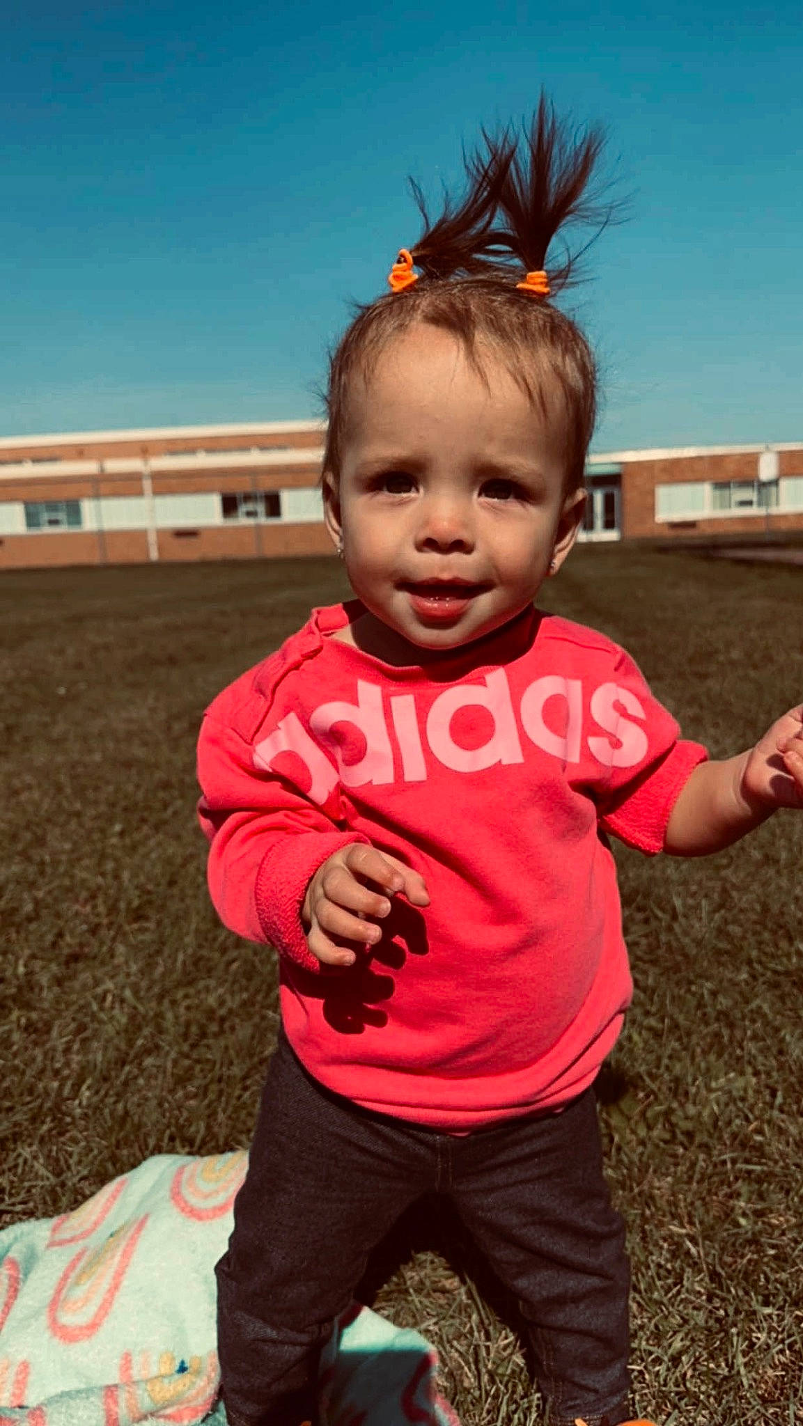 Braelynn is registered to the contest to win money with this photo: chin, cool, facial_expression, fun, gesture, grass, hand, happy, head, leisure, people_in_nature, person, pink, recreation, skin, sky, sleeve, smile, summer, toddler