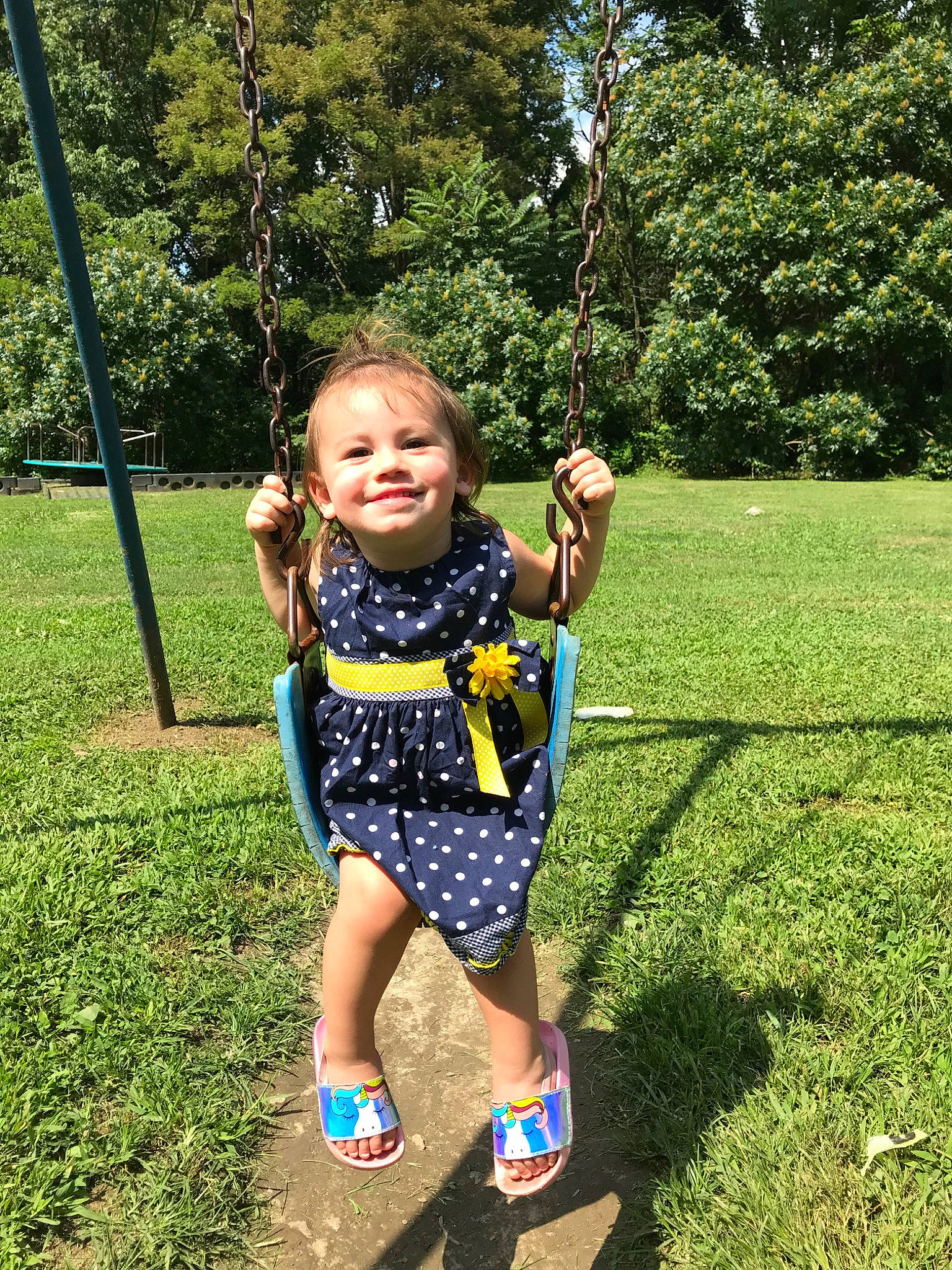 Hazel joined the competition — help win amazing prizes! baby_toddler_clothing, child, grass_family, happy, human_settlement, joy, leaf, outdoor_play_equipment, park, pattern, people_in_nature, person, play, playground, public_space, sandal, spring, summer, swing, toddler